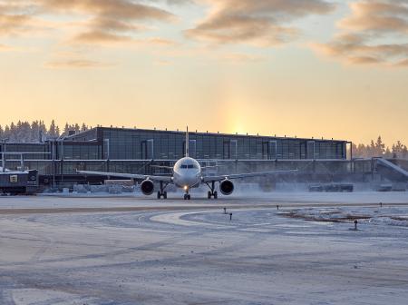 Talvinen kuva lentokoneesta ja terminaalirakennuksesta.