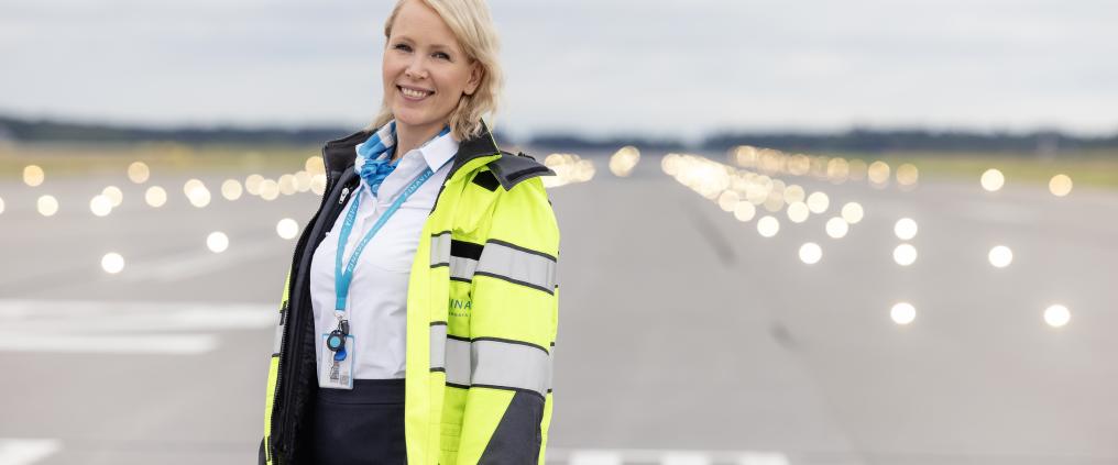 Kuvassa Oulun lentoaseman Leena Ylitalo kiitotien edustalla huomioliivi päällään