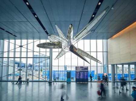 Suuri taideteos roikkuu nonSchengenin eteläsiiven katosta, Helsinki-Vantaan lentoasemalla.