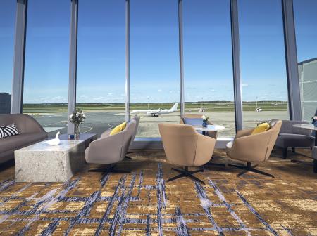 Lounge chairs by floor to ceiling glass windows at Plaza Premium Lounge.