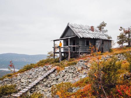 Mies istuu mökin kuistilla Levillä