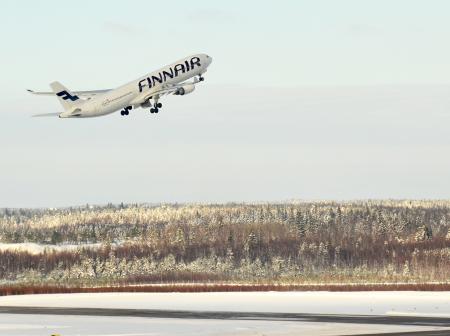 An finnair airplane taking off during winter.