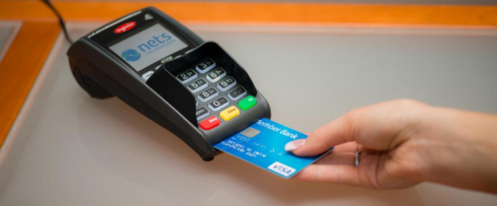Hand removing credit card out of card payment machine.