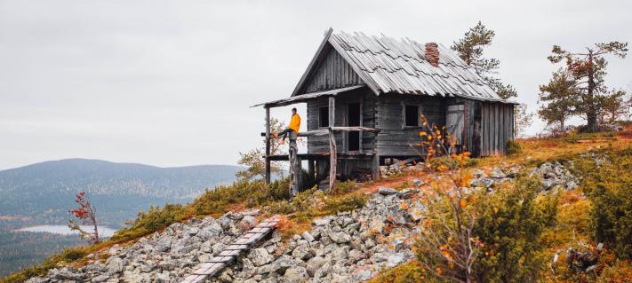 Mies istuu mökin kuistilla Levillä